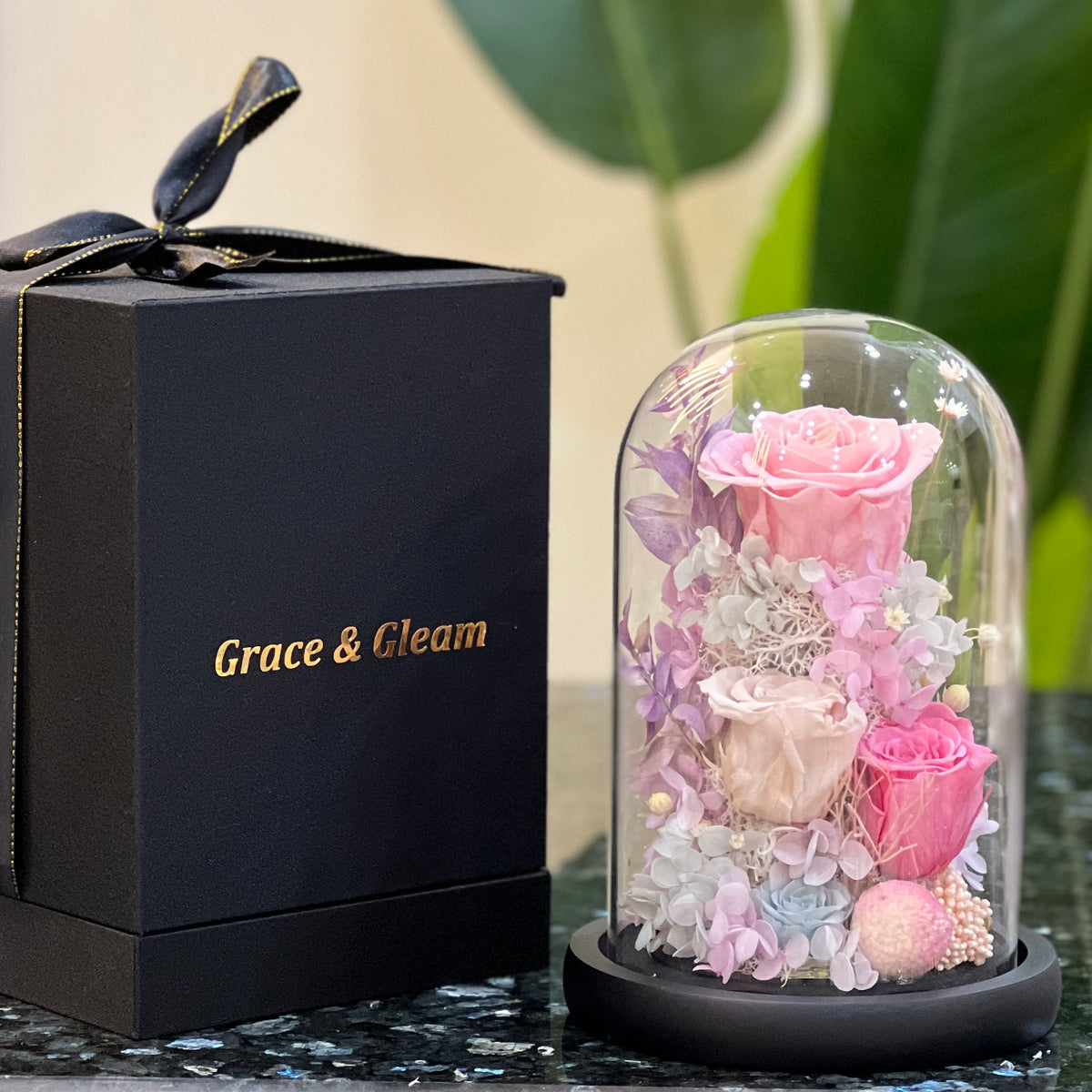 Blush Eternelle preserved flowers dome beside a Grace & Gleam gift box