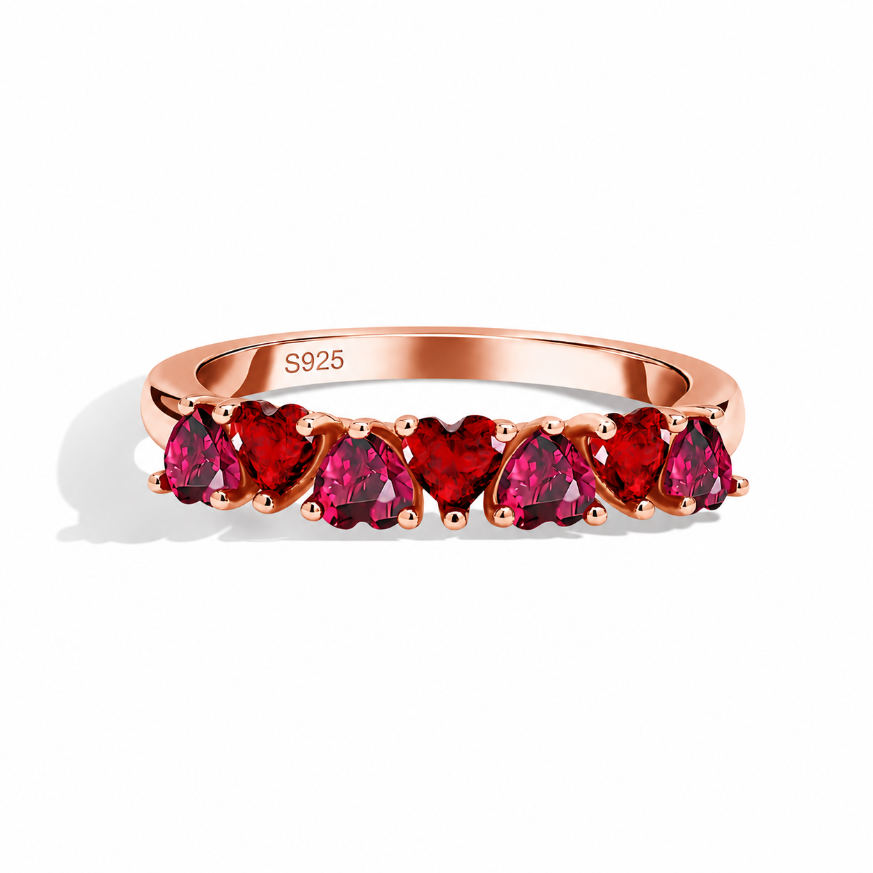 Rose gold heart ring featuring alternating ruby and garnet zircon heart stones