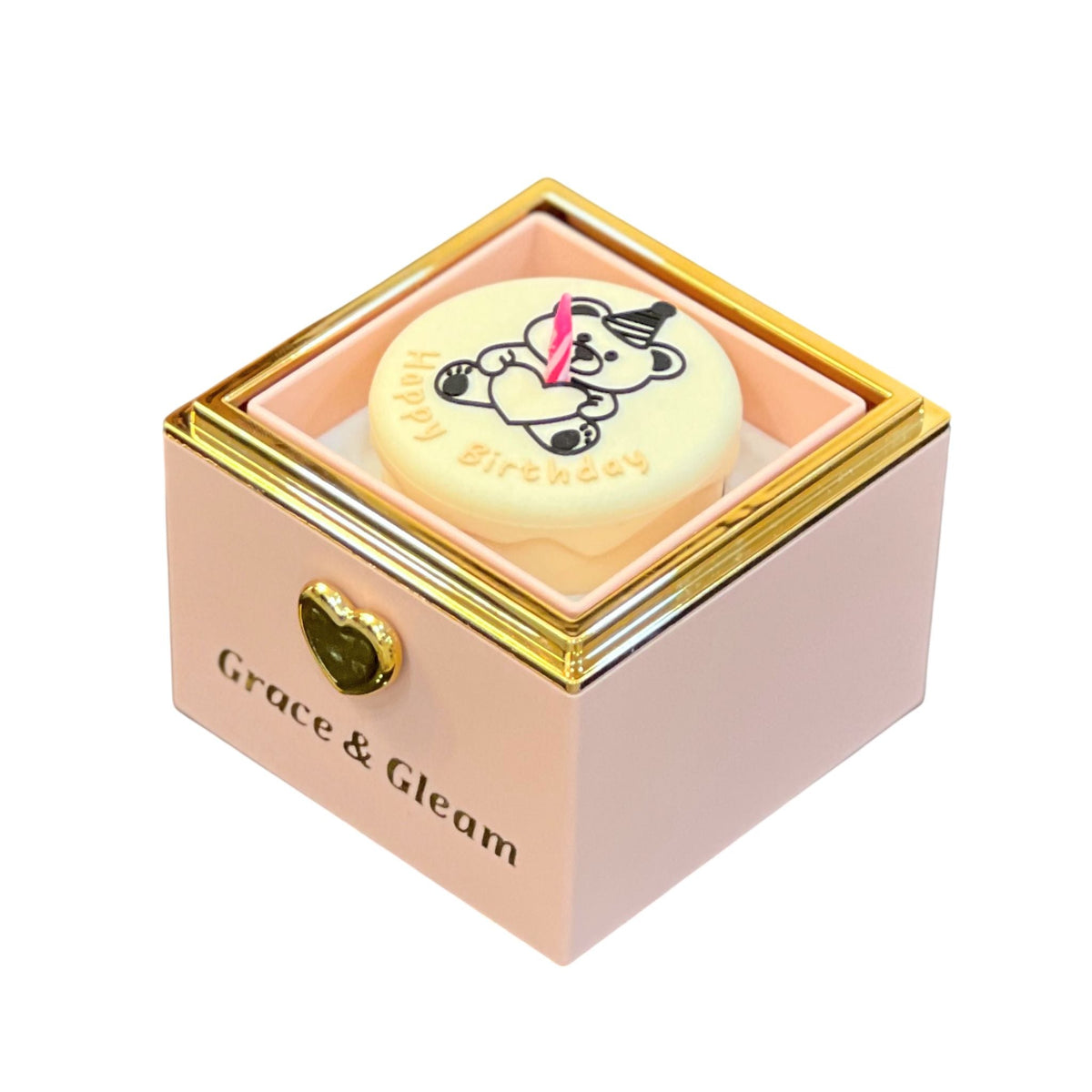 Close-up of pink candle-lit birthday box with teddy bear Happy Birthday cake top and pink candle