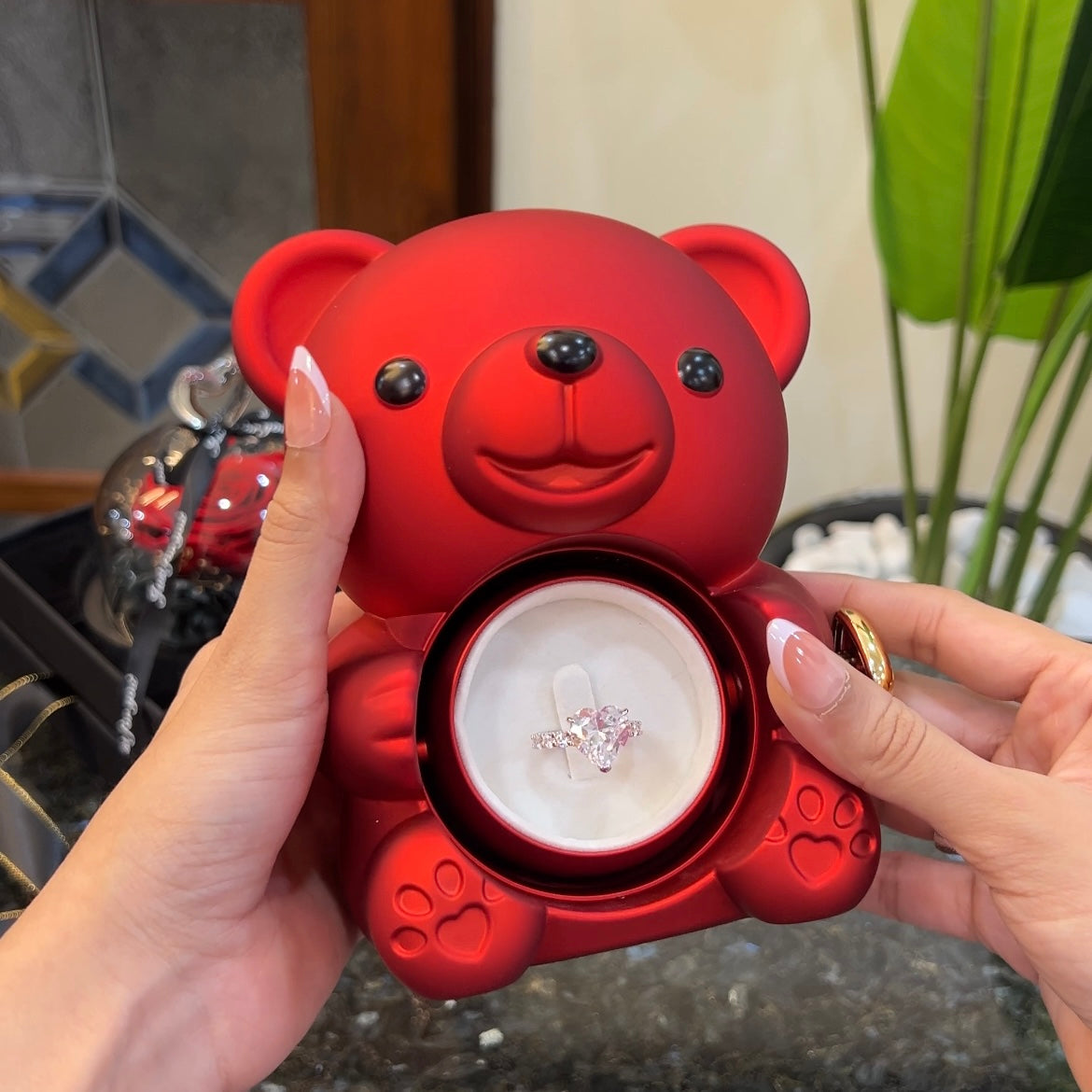 Diamond heart ring inside hidden compartment of red teddy bear rose box