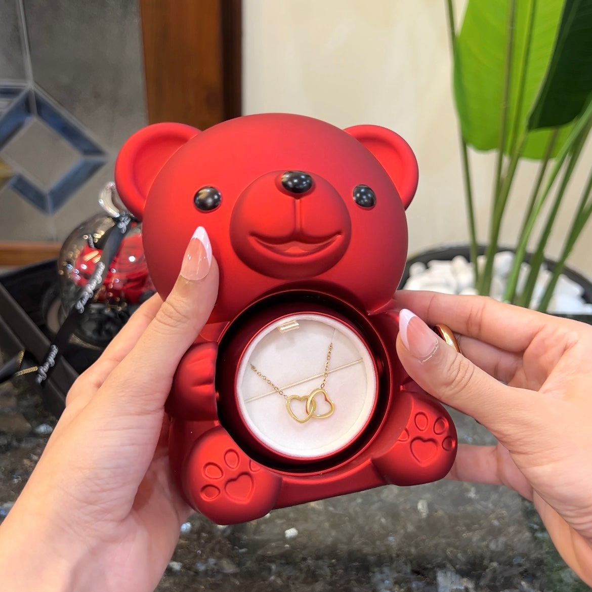 Double heart necklace inside hidden compartment of purple teddy bear rose box
