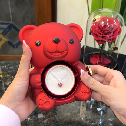 Elite heart pendant on chain inside hidden compartment of red teddy bear rose box