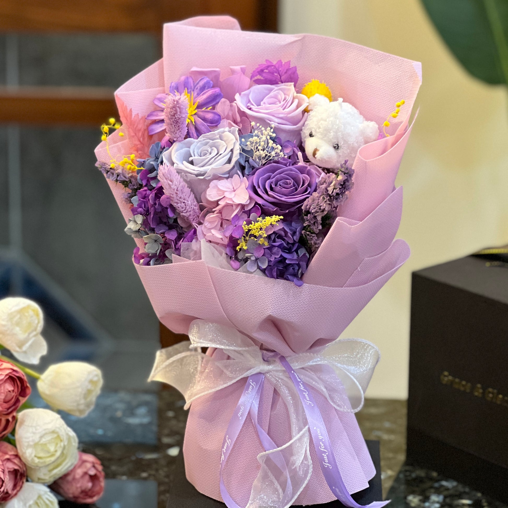 Purple preserved rose bouquet with a teddy bear, hand-wrapped