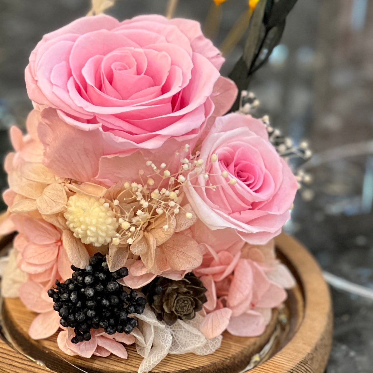 Close-up of preserved pink roses with hydrangea, gypsophila and dried accents