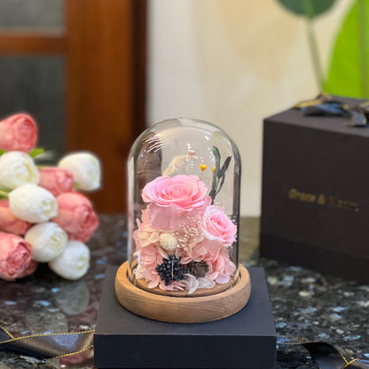 Pink forever flowers dome - preserved pink roses and hydrangea under a glass dome beside a Grace & Gleam gift box