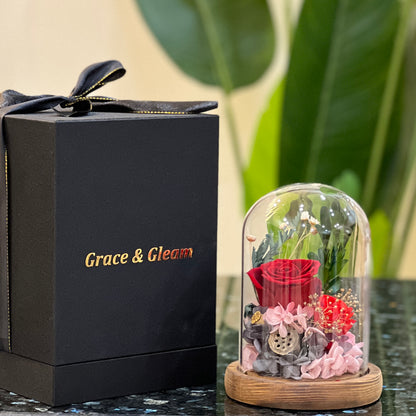 Red forever flowers dome beside a Grace & Gleam gift box