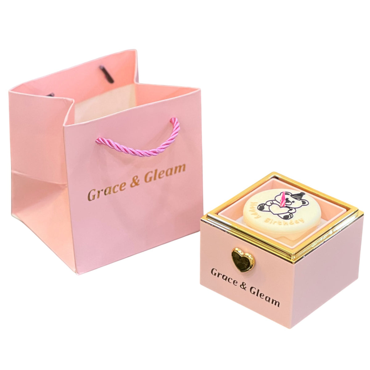 Surprise birthday gift box in pink with Happy Birthday cake top, candle and Grace & Gleam gift bag